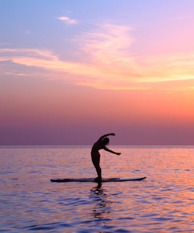 Yoga trainer over sunset background